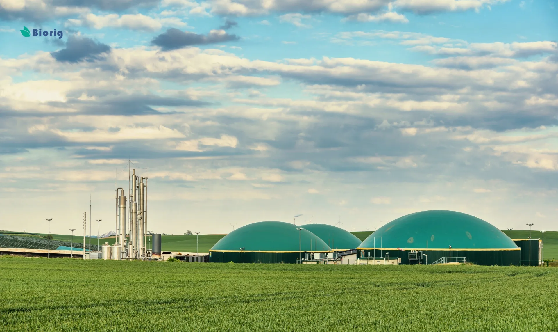Planta de biometano con cúpulas verdes y torres de proceso sobre un campo